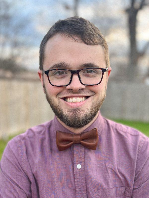 view of a young man in a bowtie with brown hair and brown eyes
