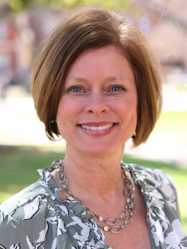 view of a smiling woman with short hair and a broad smile